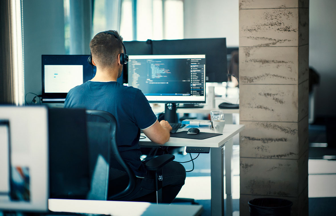 Eine arbeitende Person an ihrem PC im Büro